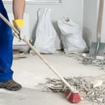 Guia de limpeza pós-obra passo a passo: Profissional removendo resíduos de cimento com produtos Serlimq.