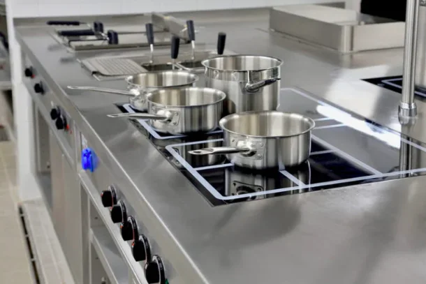 Higienização de cozinhas industriais: bancada de inox profissional sendo limpa com produtos Serlimq em Salvador.
