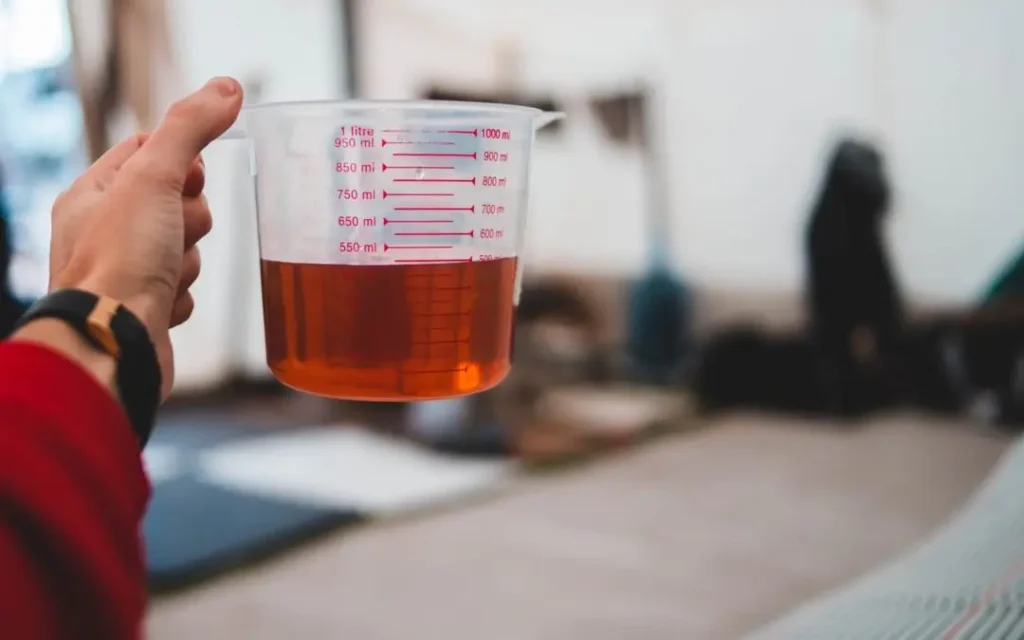 Como diluir Solupan concentrado utilizando copo medidor para garantir a proporção correta de água.