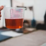 Como diluir Solupan concentrado utilizando copo medidor para garantir a proporção correta de água.