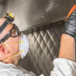 Profissional utilizando luvas de proteção para mostrar como limpar coifa industrial em cozinha de restaurante em Salvador
